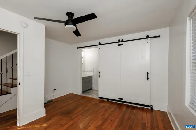 a view of empty room with wooden floor