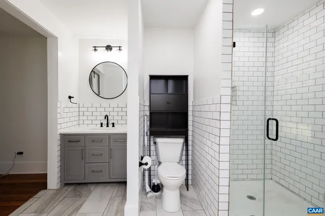 a bathroom with a double vanity sink toilet mirror and shower