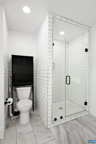a bathroom with a toilet and a shower