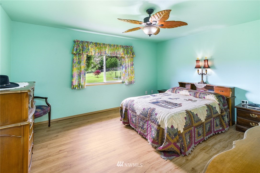 1450 Southeast Spruce Road Port Orchard, WA 98367 - Photo 11 of 40 a bedroom with a bed and a chandelier