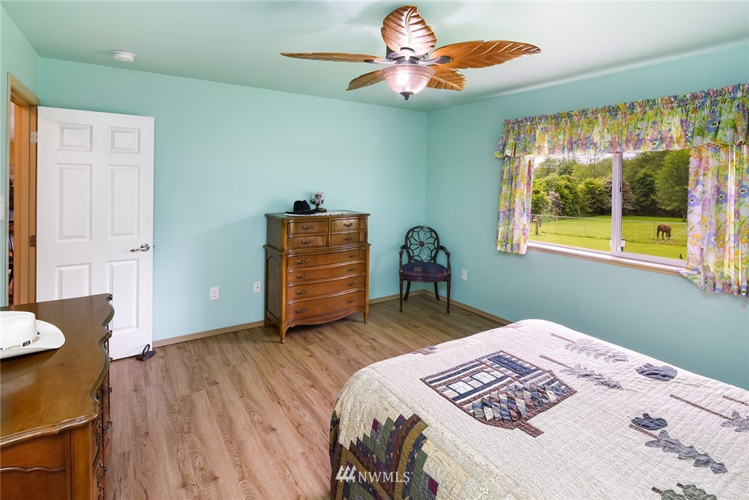 1450 Southeast Spruce Road Port Orchard, WA 98367 - Photo 12 of 40 a bedroom with a bed and a chandelier