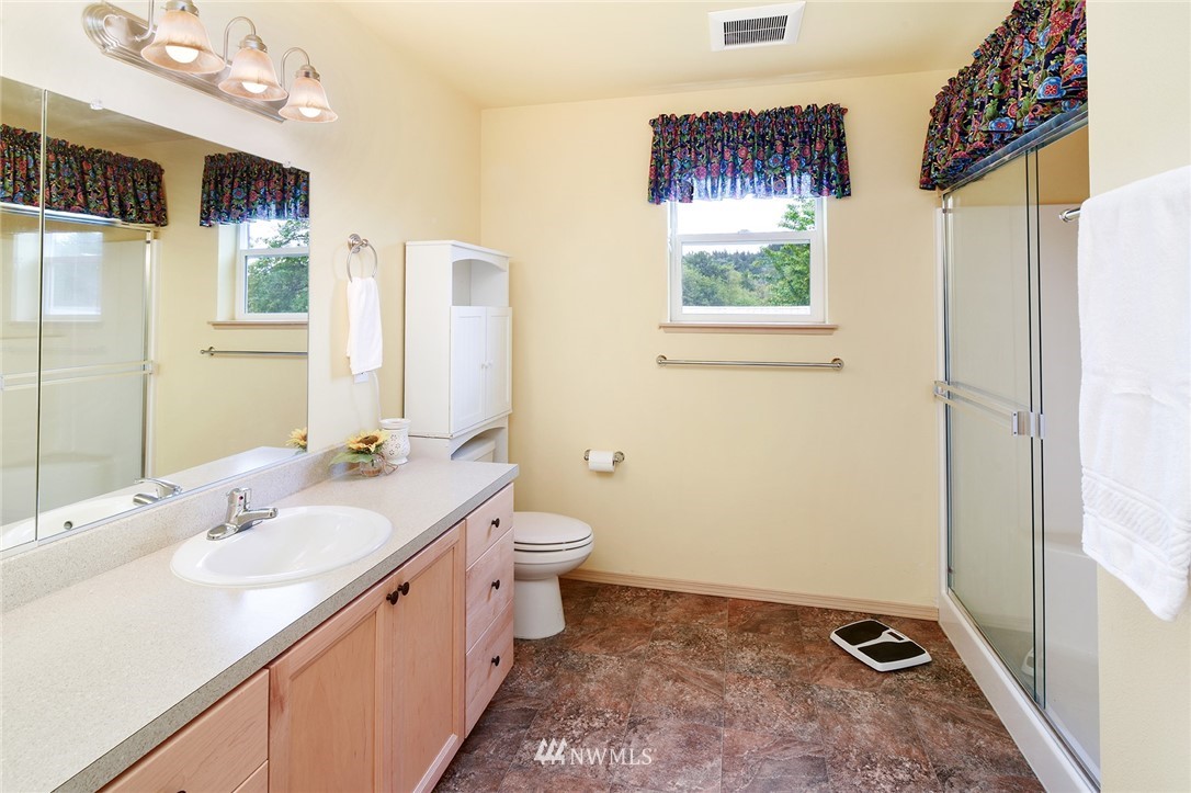 1450 Southeast Spruce Road Port Orchard, WA 98367 - Photo 16 of 40 a bathroom with a double vanity sink toilet and shower