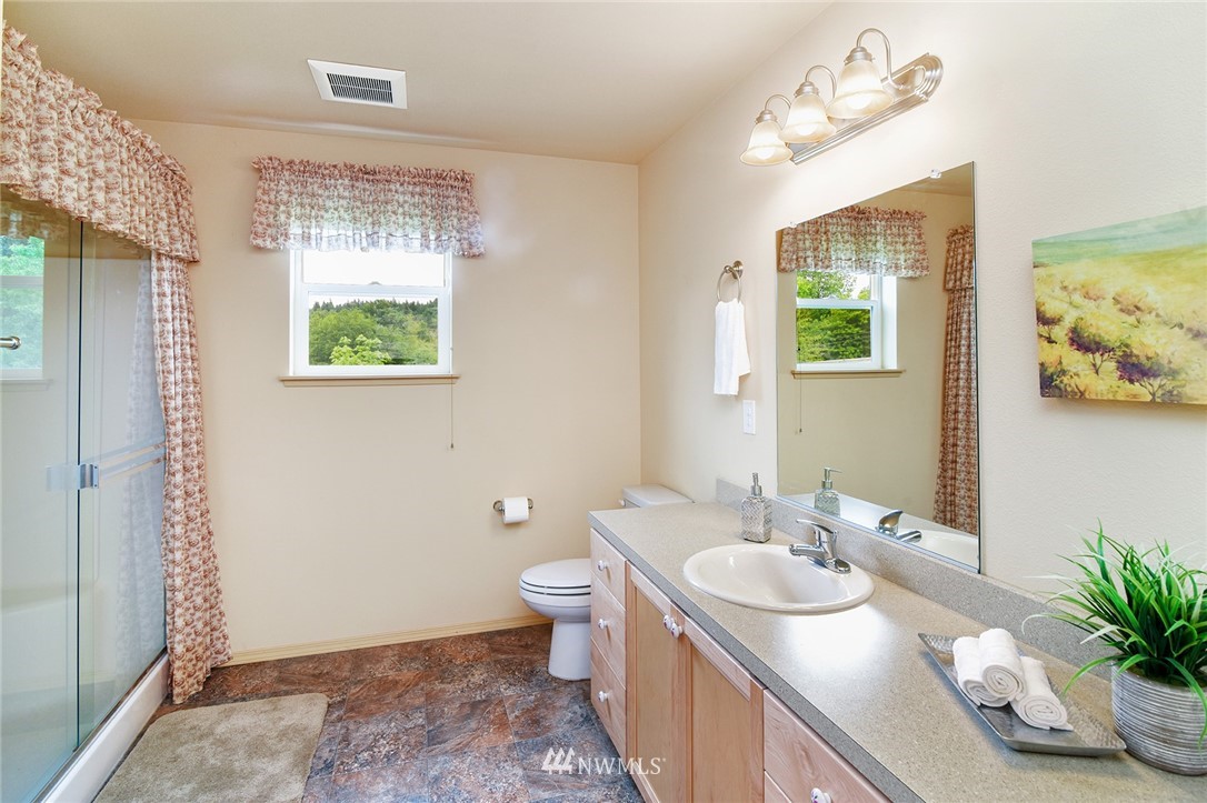 1450 Southeast Spruce Road Port Orchard, WA 98367 - Photo 19 of 40 a bathroom with a granite countertop sink a toilet and a window