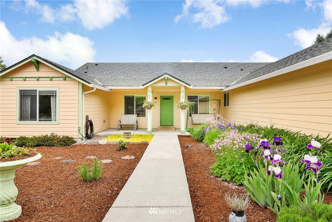 1450 Southeast Spruce Road Port Orchard, WA 98367 - Photo 40 of 40 a view of a house with large windows and flower plants