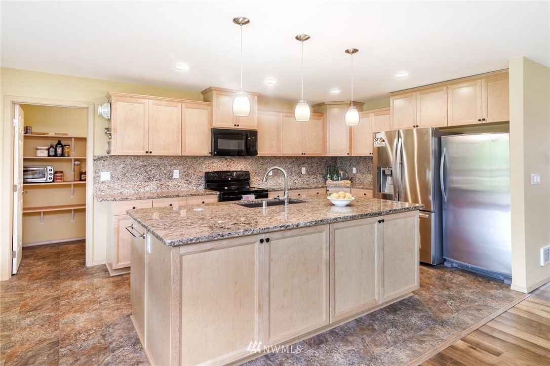 1450 Southeast Spruce Road Port Orchard, WA 98367 - Photo 6 of 40 a kitchen with stainless steel appliances granite countertop a refrigerator a stove and a sink