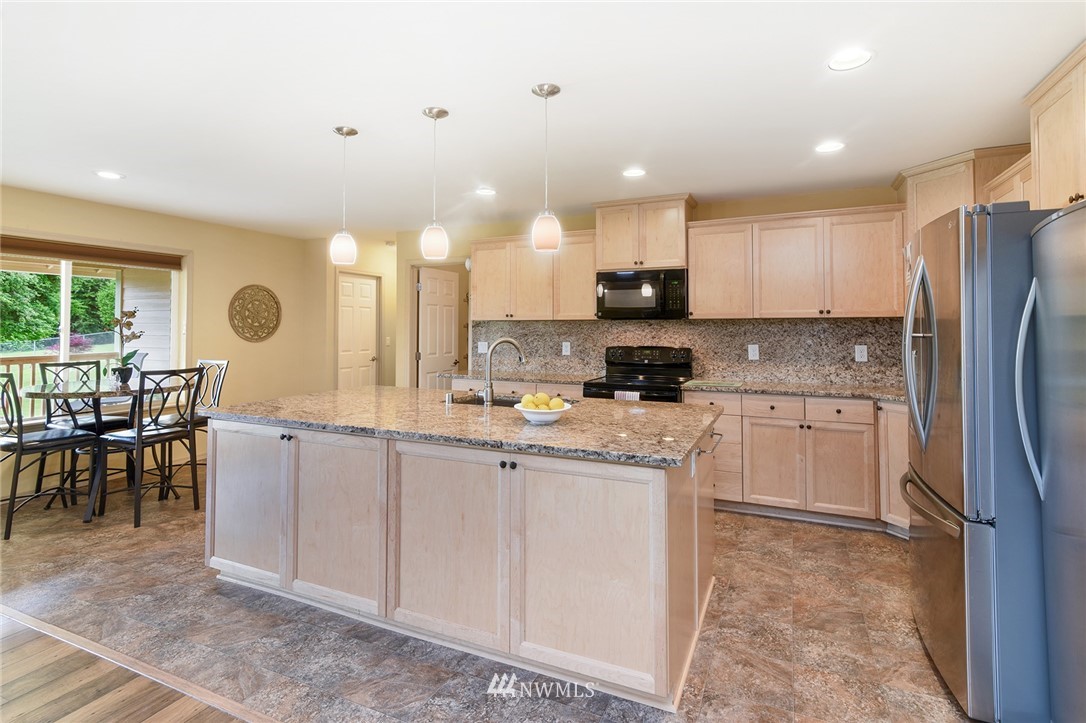 1450 Southeast Spruce Road Port Orchard, WA 98367 - Photo 9 of 40 a kitchen with stainless steel appliances granite countertop a refrigerator sink and cabinets