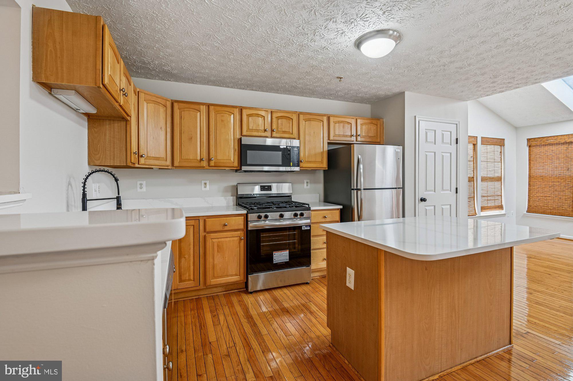 2670 Rainy Spring Court Odenton, MD 21113 - Photo 13 of 79 a kitchen with stainless steel appliances granite countertop a refrigerator a stove and a sink with wooden floors