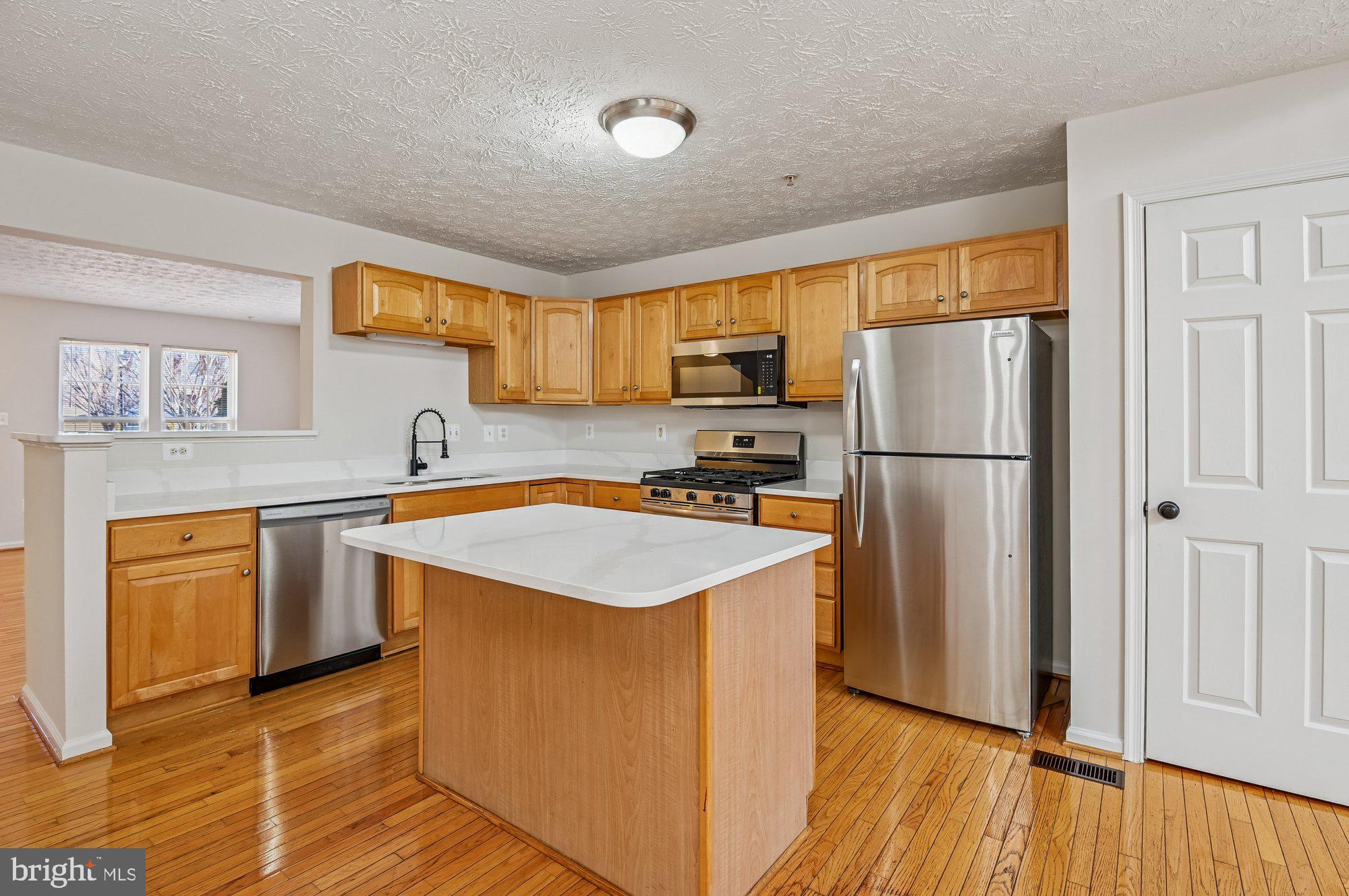 2670 Rainy Spring Court Odenton, MD 21113 - Photo 14 of 79 a kitchen with stainless steel appliances granite countertop a refrigerator a sink dishwasher a stove top oven a refrigerator with island and chairs