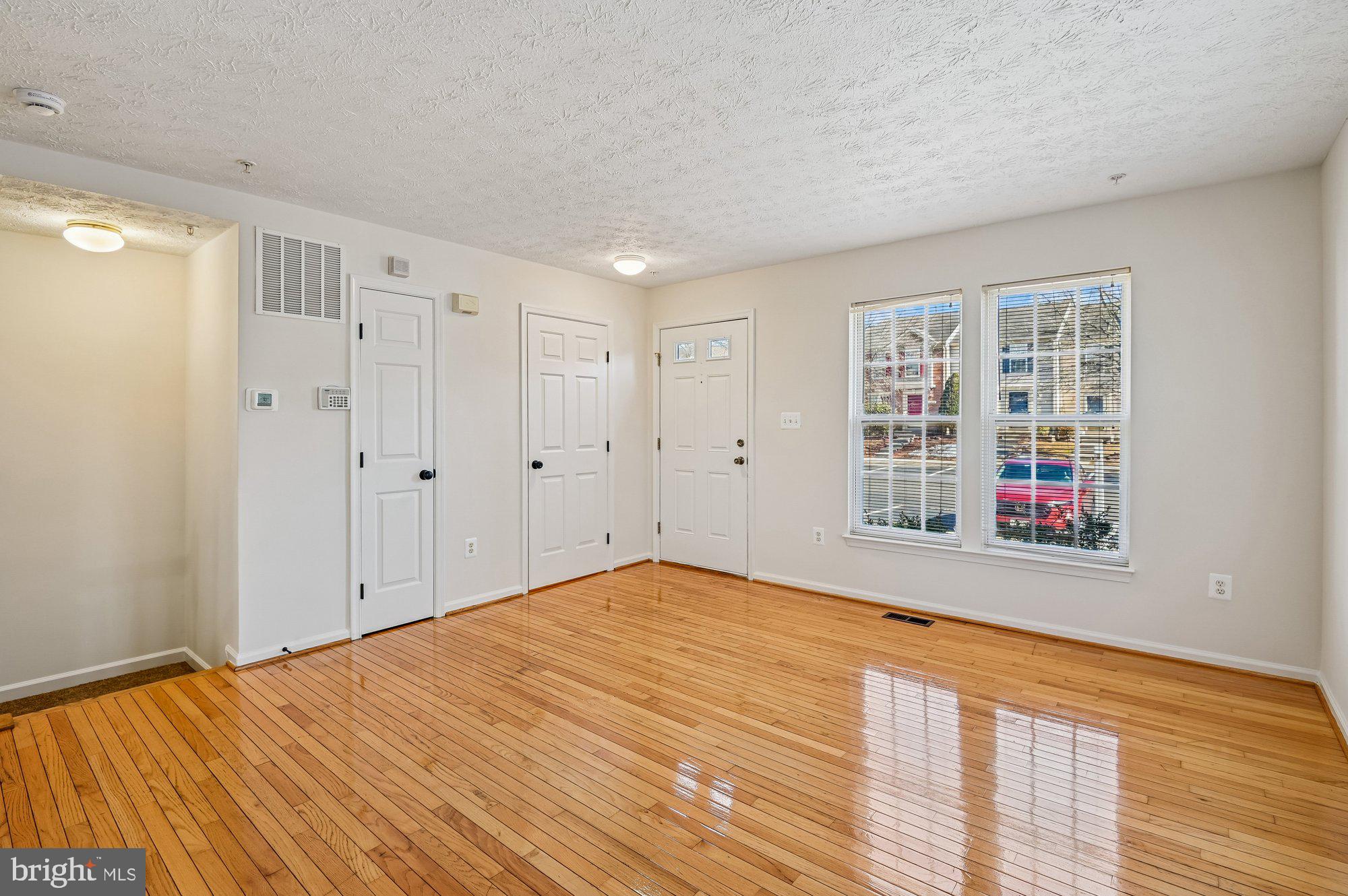 2670 Rainy Spring Court Odenton, MD 21113 - Photo 8 of 79 a view of an empty room with wooden floor and a window