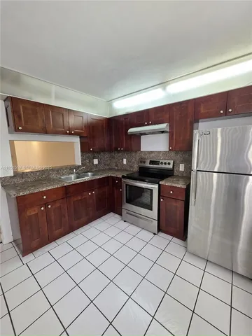 a kitchen with granite countertop a refrigerator and a sink