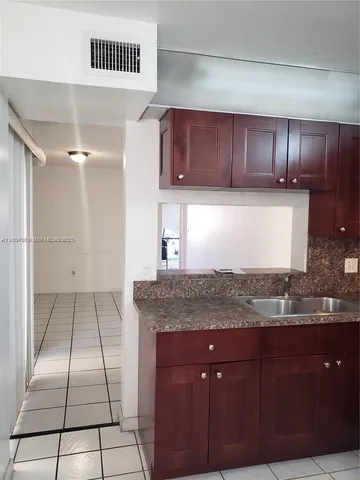 a kitchen with a sink a stove and cabinets