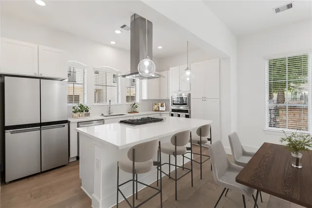 a kitchen with a sink a kitchen island and stainless steel appliances