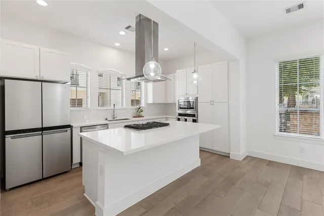 a kitchen with a sink a stove a refrigerator and white cabinets