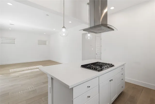 a kitchen with a stove cabinets and wooden floor