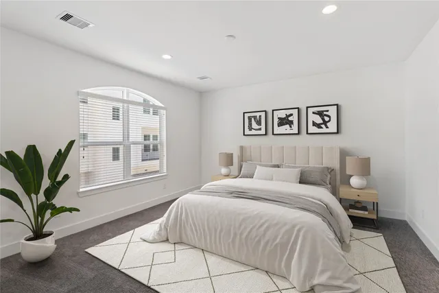 a spacious bedroom with a large bed and a potted plant