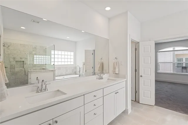 a spacious bathroom with double sink and a mirror