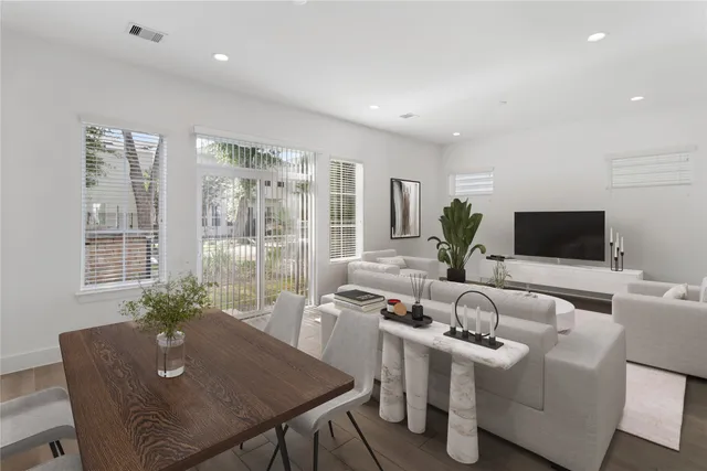 a living room with furniture a flat screen tv and a large window