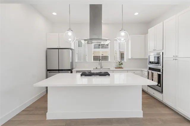 a large kitchen with kitchen island a sink stainless steel appliances and cabinets