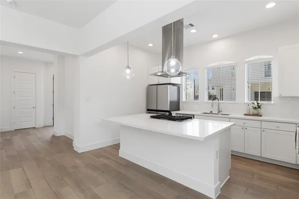 a kitchen with stainless steel appliances granite countertop a sink a stove and a wooden floors