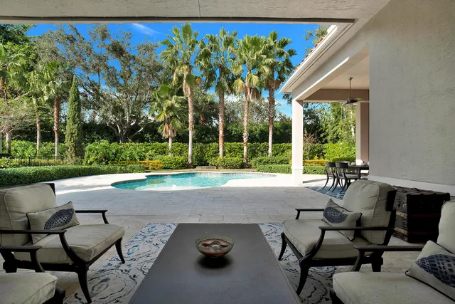 a roof deck with table and chairs and potted plants