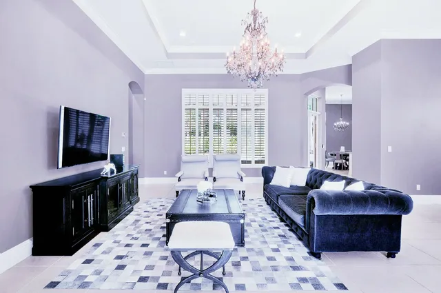 a living room with furniture a chandelier and a flat screen tv
