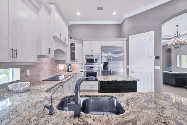 a kitchen with stainless steel appliances kitchen island granite countertop a stove and a sink