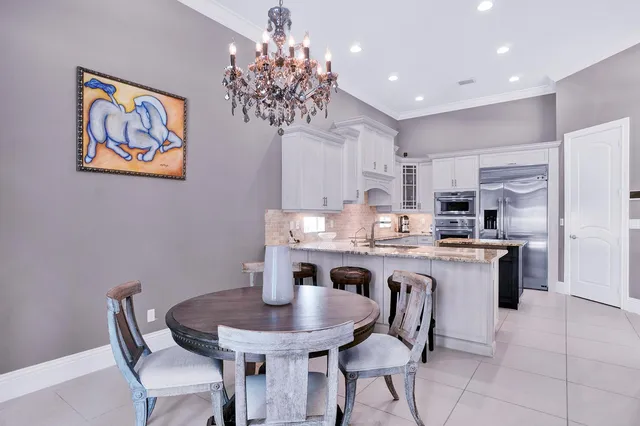 a kitchen with stainless steel appliances granite countertop a dining table and chairs