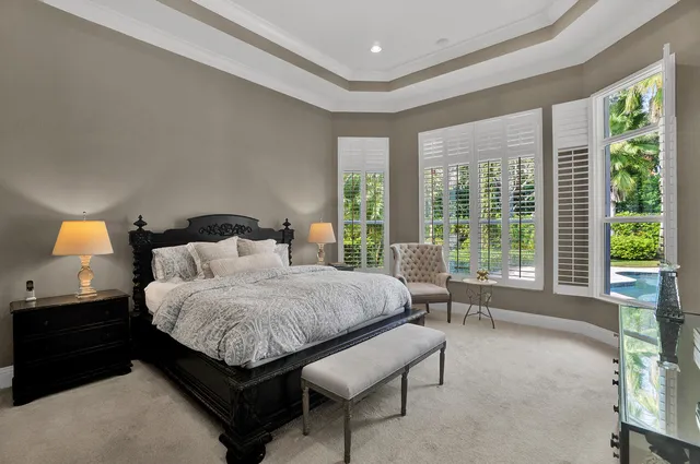 a spacious bedroom with a bed and large windows