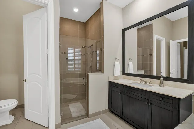 a bathroom with a double vanity sink mirror and toilet