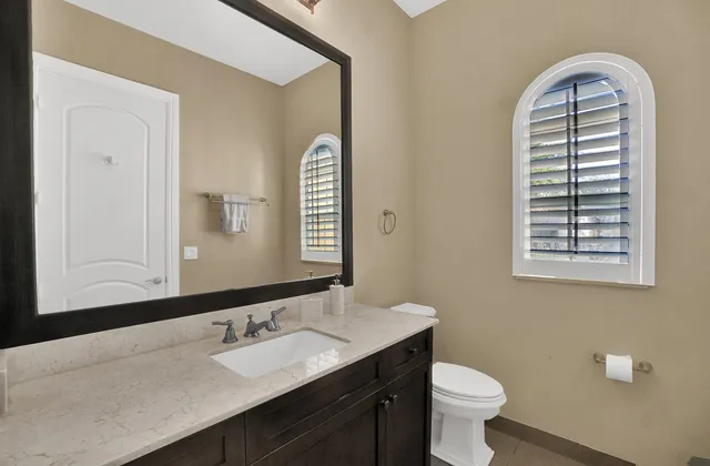 a bathroom with a sink a toilet and a mirror