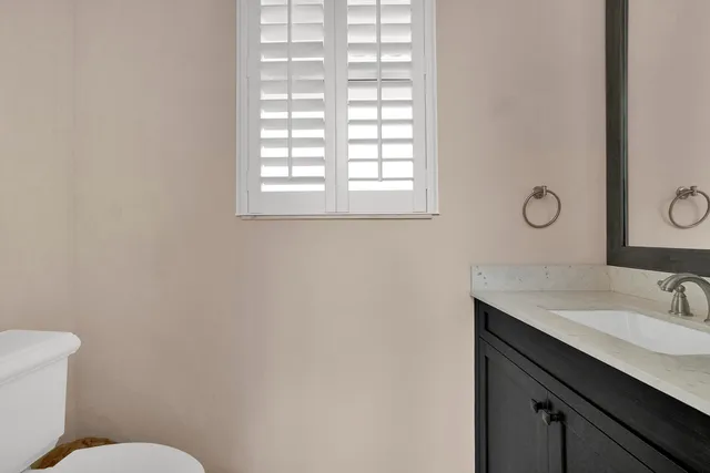a bathroom with a sink mirror vanity and a toilet