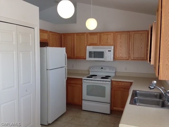 3207 54th Street West Lehigh Acres, FL 33971 - Photo 2 of 10 a kitchen with a refrigerator sink and cabinets