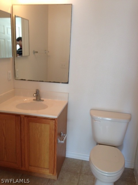 3207 54th Street West Lehigh Acres, FL 33971 - Photo 8 of 10 a bathroom with a toilet a sink and mirror