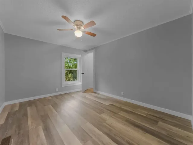 a view of an empty room with wooden floor