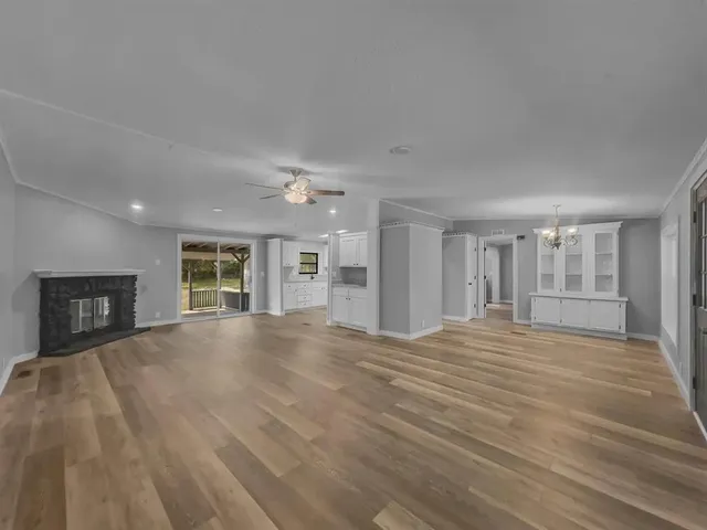 a view of an empty room with a window and fireplace