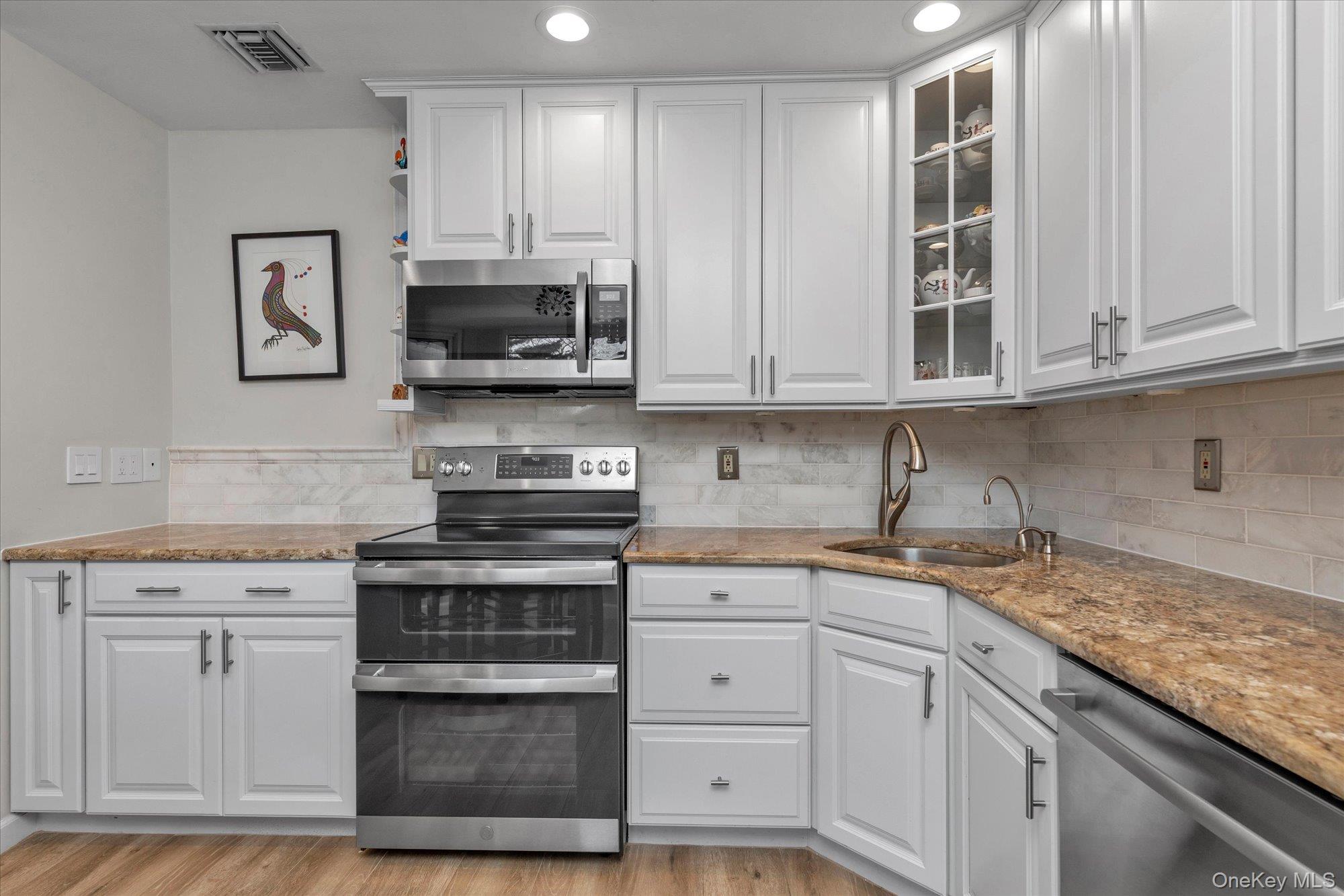 32 Ashley Circle Commack, NY 11725 - Photo 7 of 23 a kitchen with stainless steel appliances granite countertop a stove and a white cabinets