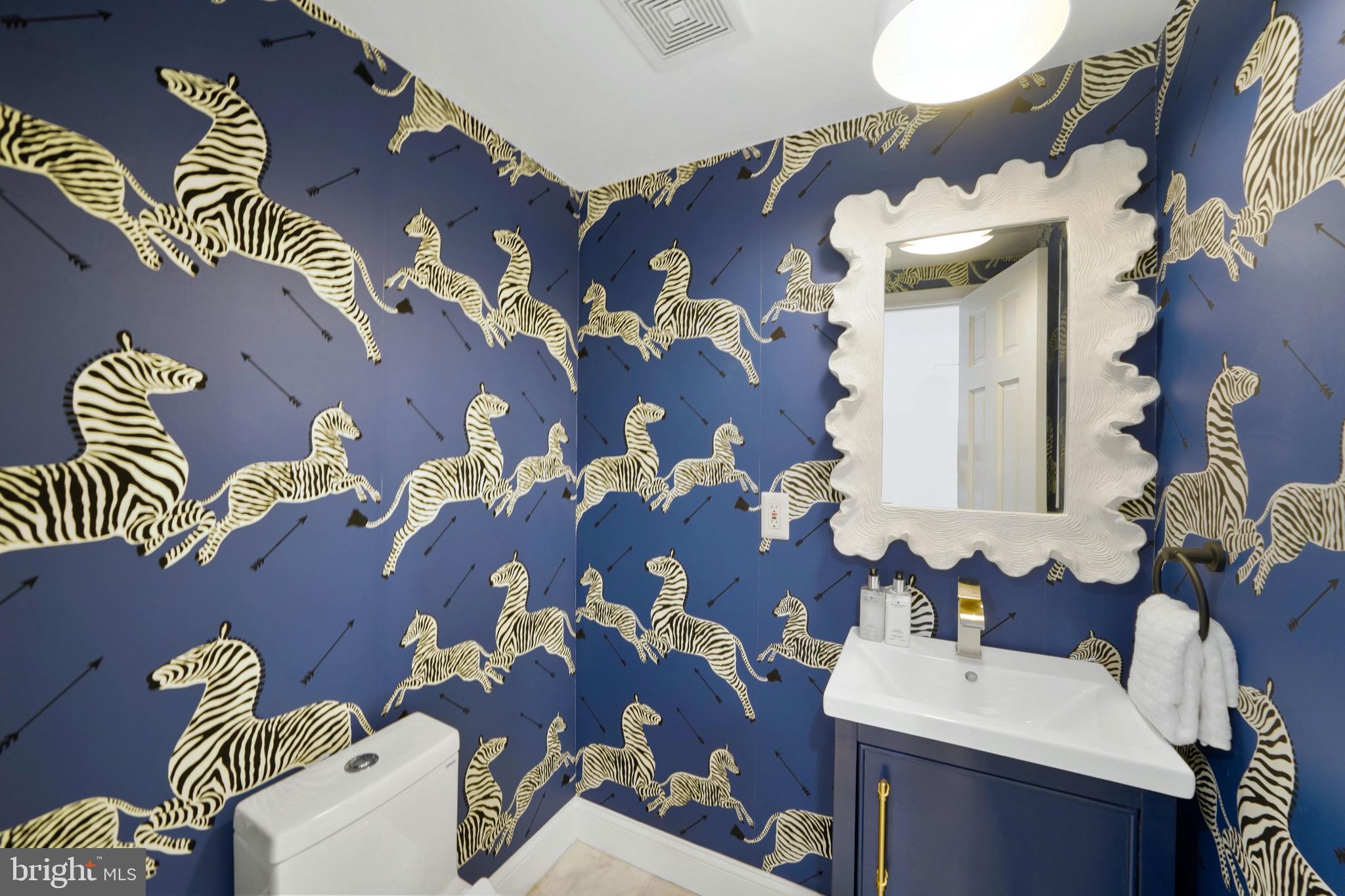 a bathroom with a sink and mirror with painted walls