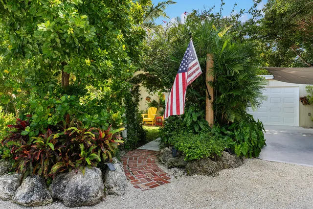 a backyard of a house with table and chairs potted plants