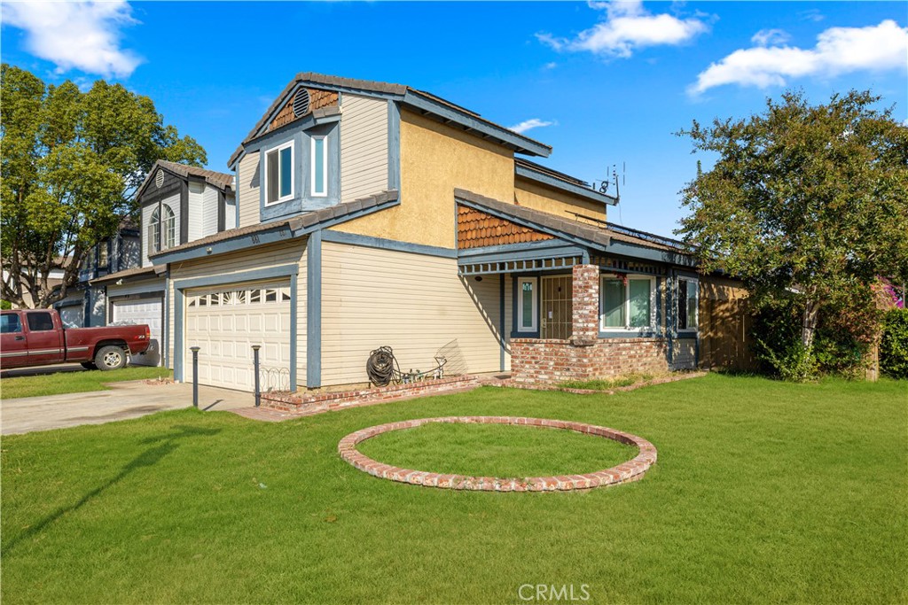 a view of a white house with a big yard and potted plants and large trees