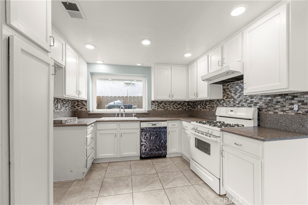 881 South Lamarr Street Rialto, CA 92376 - Photo 14 of 54 a kitchen with a stove top oven sink and cabinets