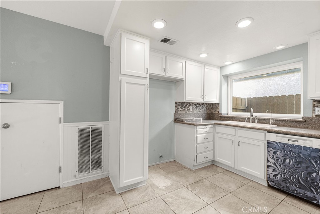881 South Lamarr Street Rialto, CA 92376 - Photo 16 of 54 a kitchen with a sink window and cabinets