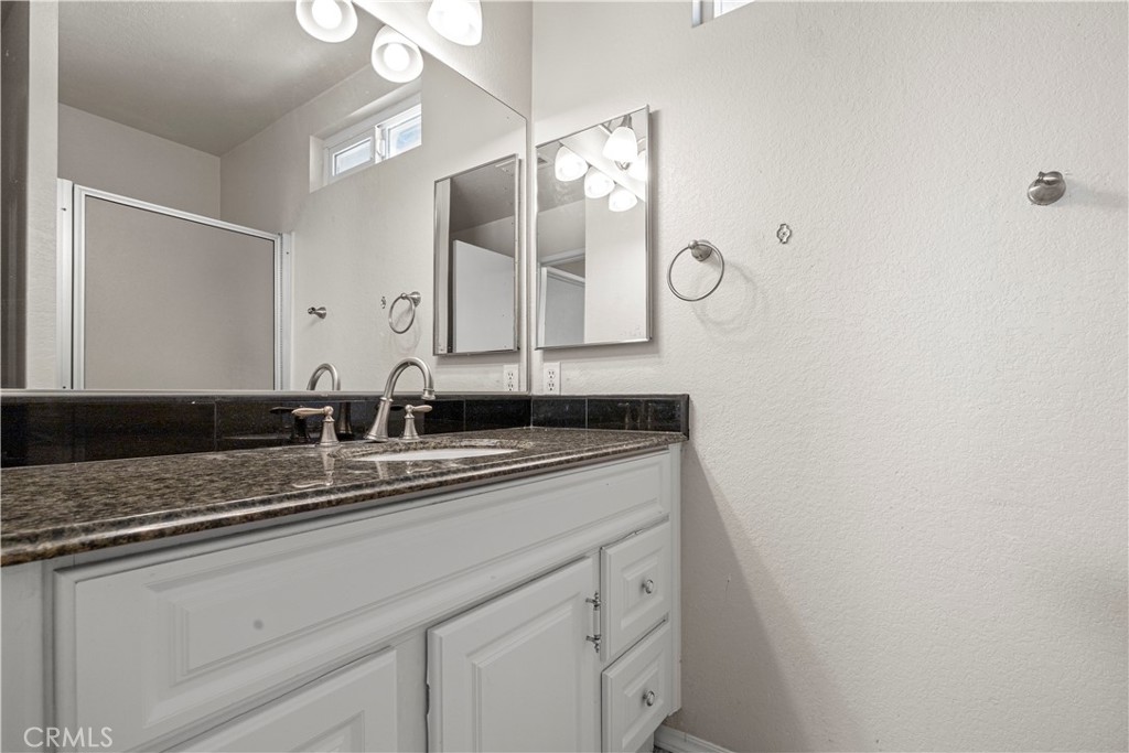 881 South Lamarr Street Rialto, CA 92376 - Photo 40 of 54 a bathroom with a granite countertop sink and a mirror