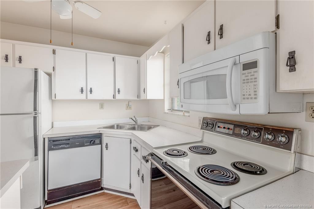 1999 Southwest Palm City Road, Unit G Stuart, FL 34994 - Photo 6 of 23 a kitchen with a stove a refrigerator and a sink