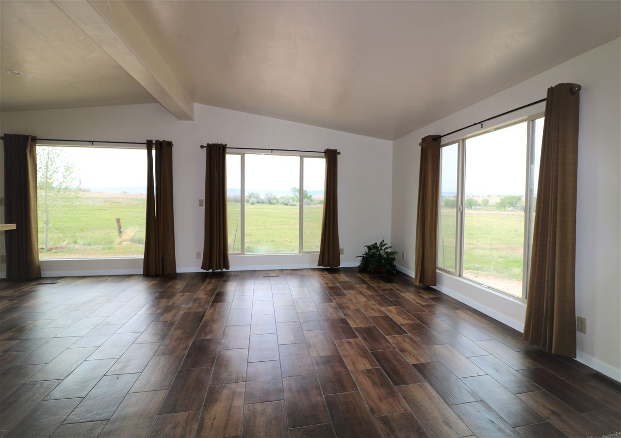 1505 10 Road Mack, CO 81525 - Photo 2 of 27 an empty room with wooden floor and windows