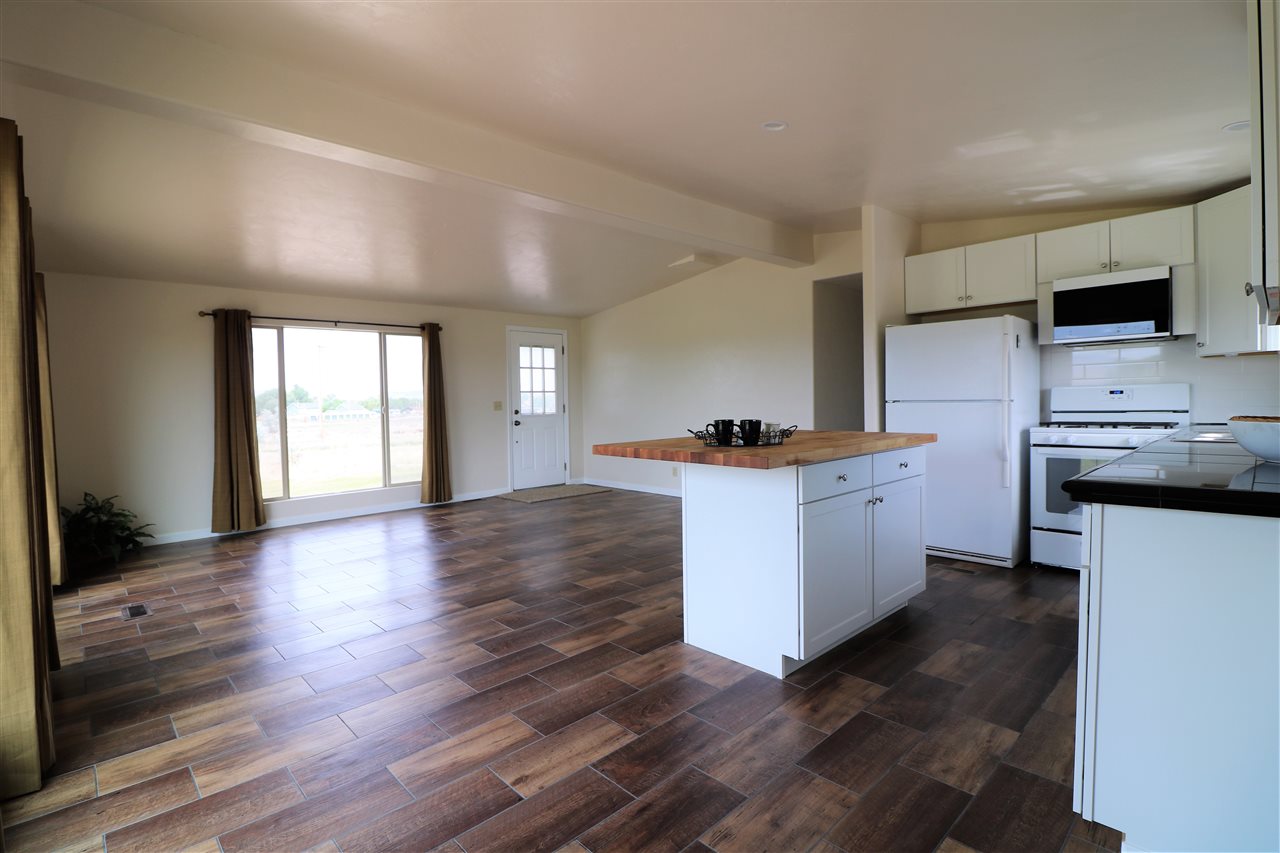 1505 10 Road Mack, CO 81525 - Photo 7 of 27 a kitchen with stainless steel appliances kitchen island wooden floors and white cabinets