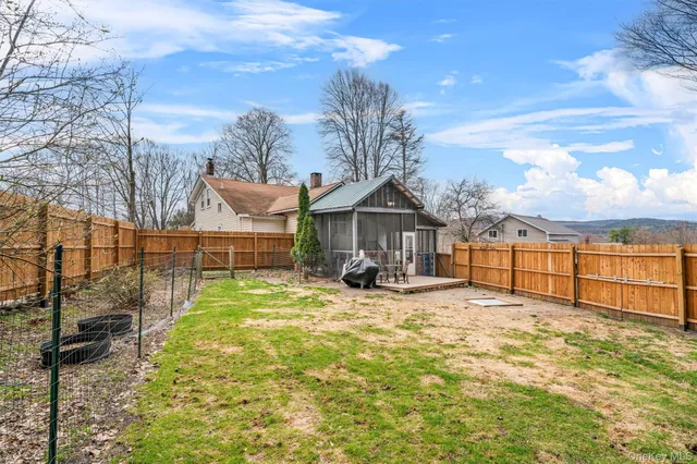a view of a house with a yard and a fence