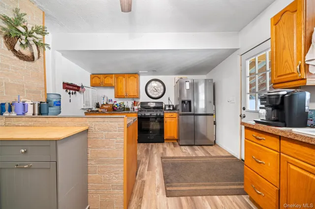 a kitchen with stainless steel appliances granite countertop a stove a sink and a microwave