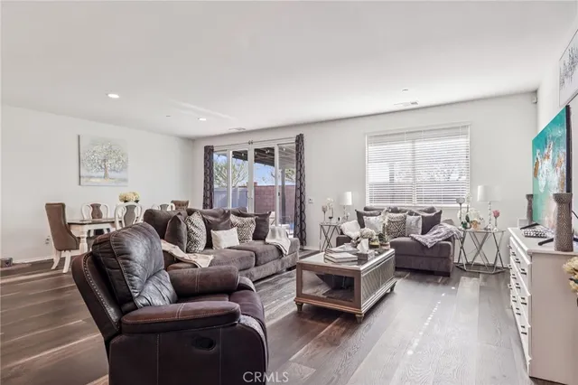 a living room with furniture wooden floor and a large window
