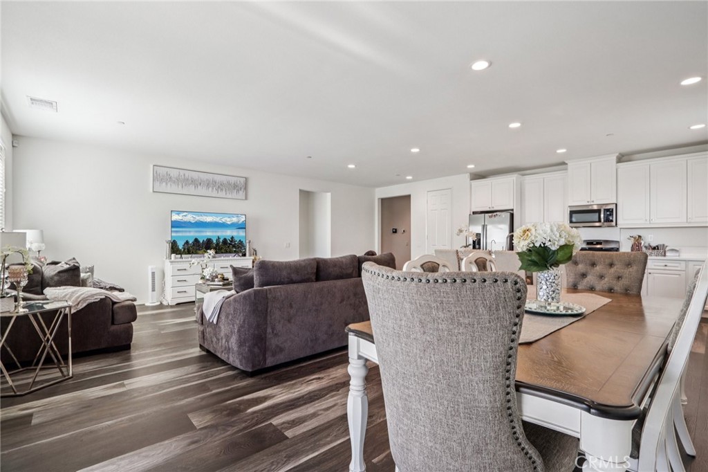 45643 Sancroft Avenue Lancaster, CA 93535 - Photo 4 of 18 a living room with furniture a wooden floor and a kitchen view