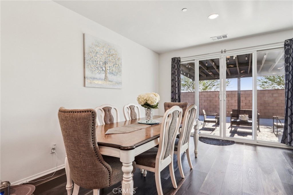45643 Sancroft Avenue Lancaster, CA 93535 - Photo 8 of 18 a dining room with furniture floor to ceiling windows and potted plants